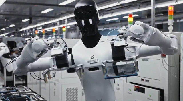 Robot umanoidi al lavoro in una fabbrica di elettronica